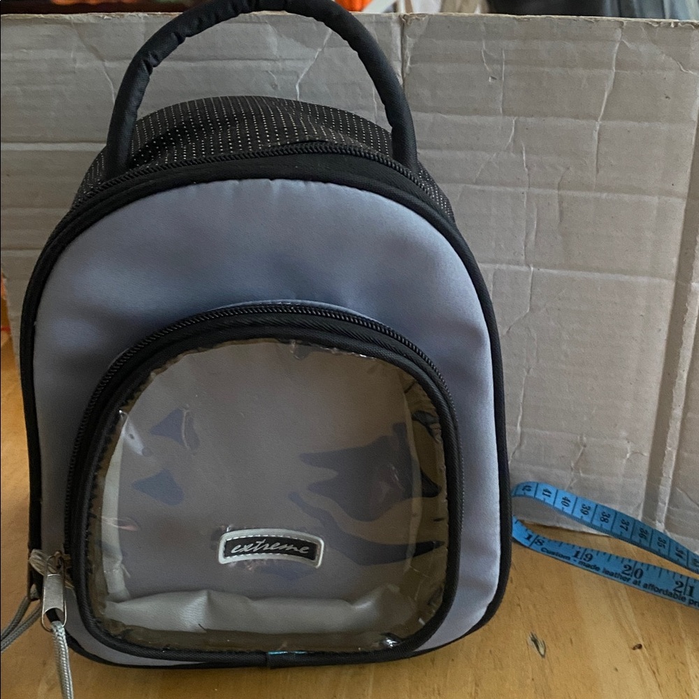 Gray and Black hand held insulated back pack shaped tote w clear front pouch.